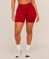 Mujer con shorts deportivos rojos de cintura alta y calcetines blancos, vista frontal