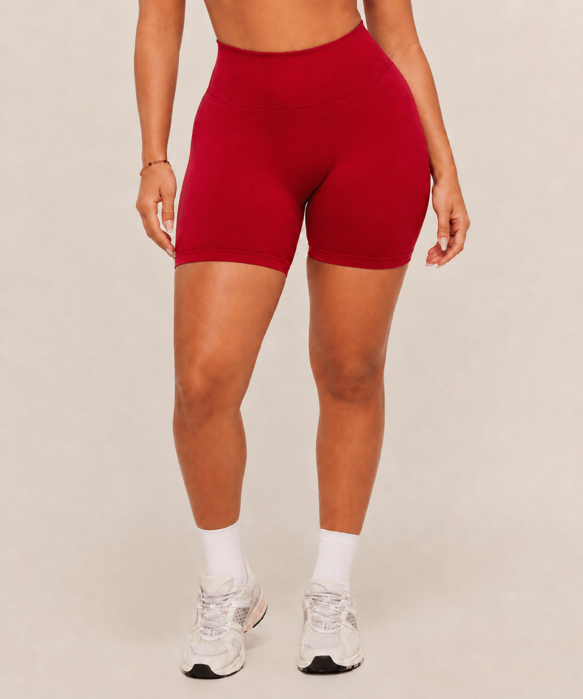 Mujer con shorts deportivos rojos de cintura alta y calcetines blancos, vista frontal