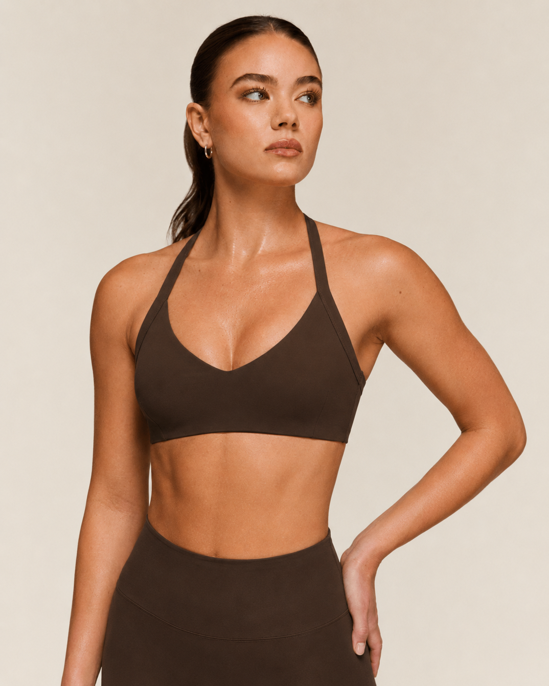 Mujer con sujetador deportivo halter color marrón con escote en V