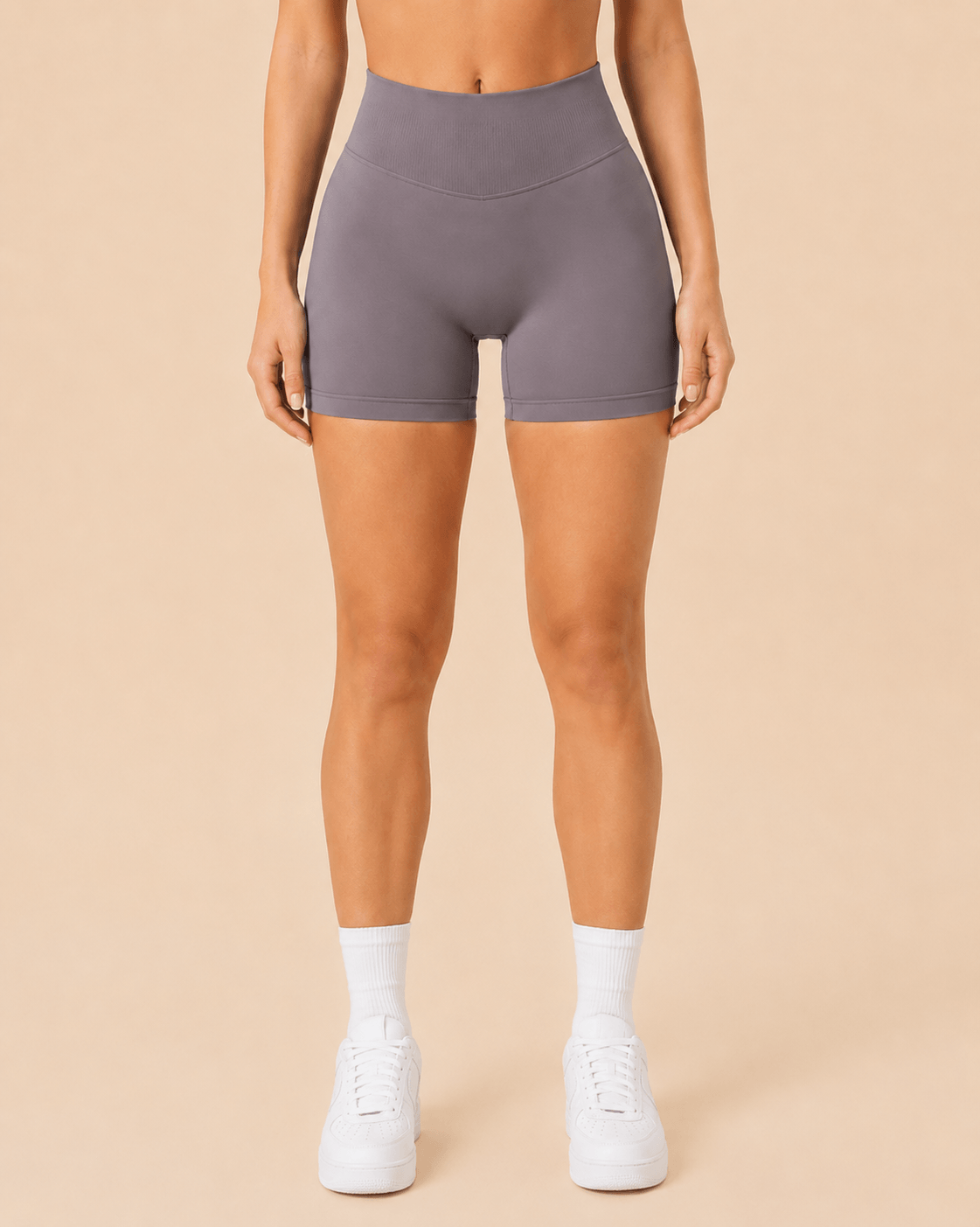Mujer con shorts deportivos marrón mushroom de cintura alta y calcetines blancos, vista frontal