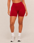 Mujer con shorts deportivos rojos de cintura alta y calcetines blancos, vista frontal