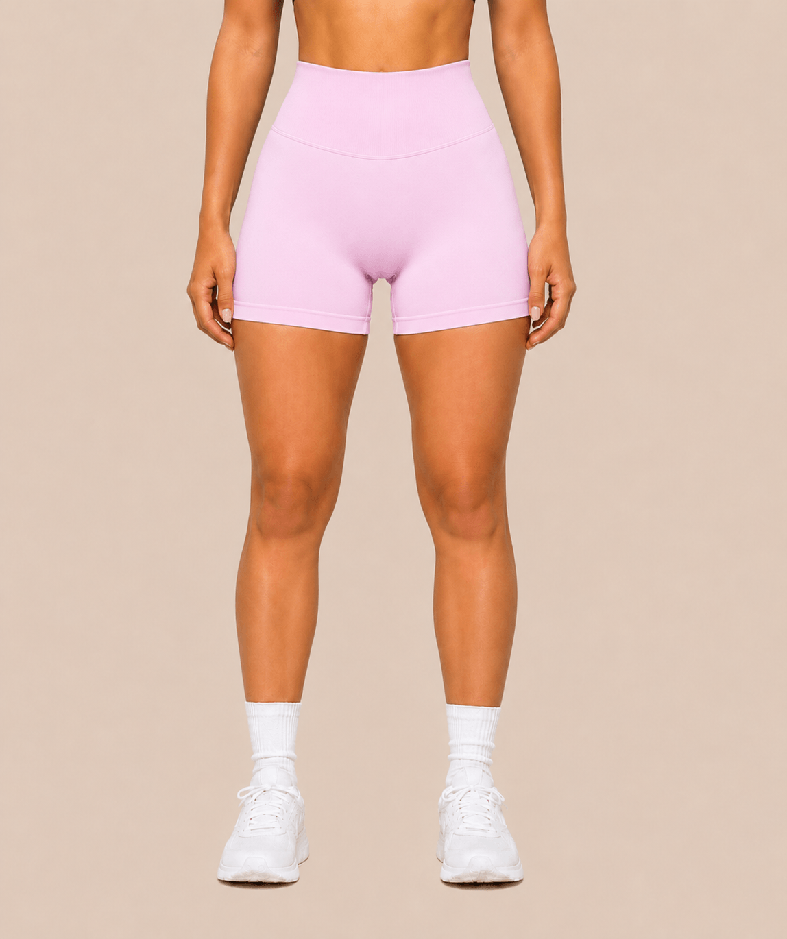Mujer con shorts deportivos rosas de cintura alta y calcetines blancos, vista frontal