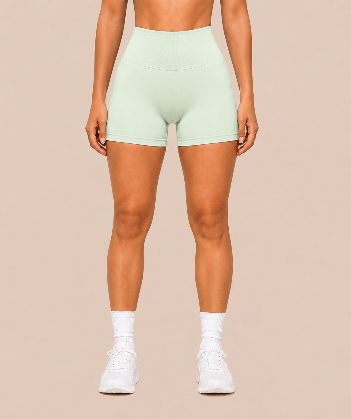 Mujer con shorts deportivos verde menta claro de cintura alta y calcetines blancos, vista frontal